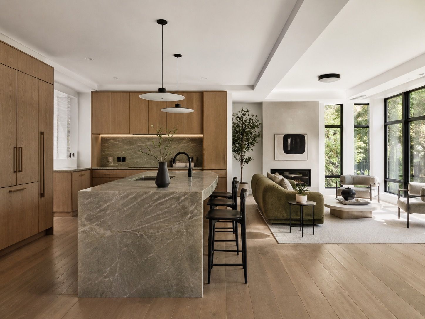 Open kitchen with a stone island, custom cabinetry, and a bright living area